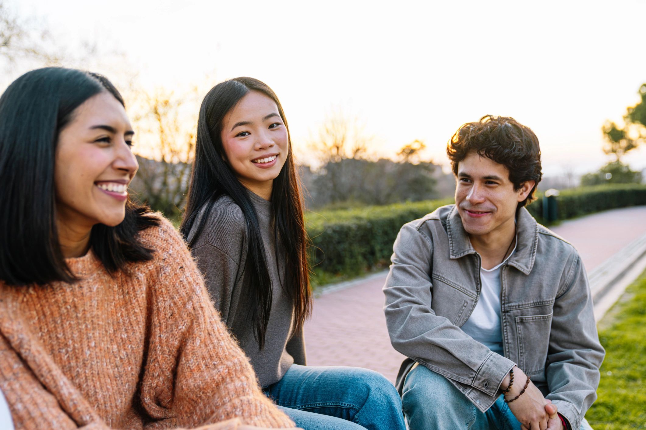 Diverse friends enjoying conversation together in an urban park at sunset